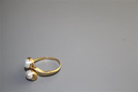 A 20th century 18ct and two stone cultured pearl set crossover ring, size O, gross weight 3.3 grams.